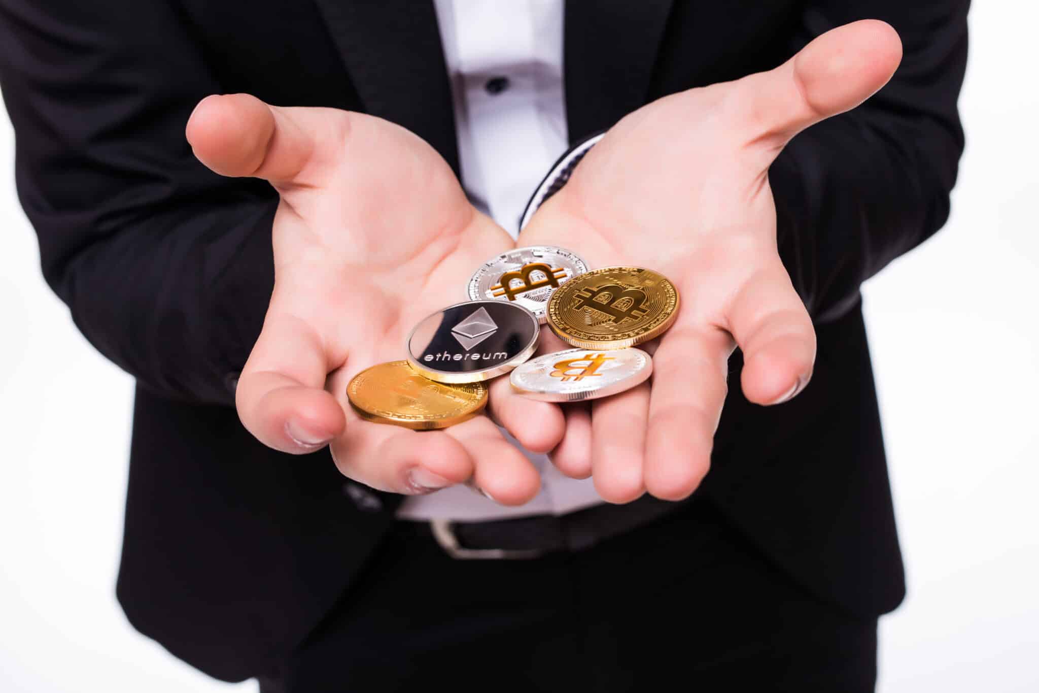 Young man isolated on white background holds bitcoin coin in his hands