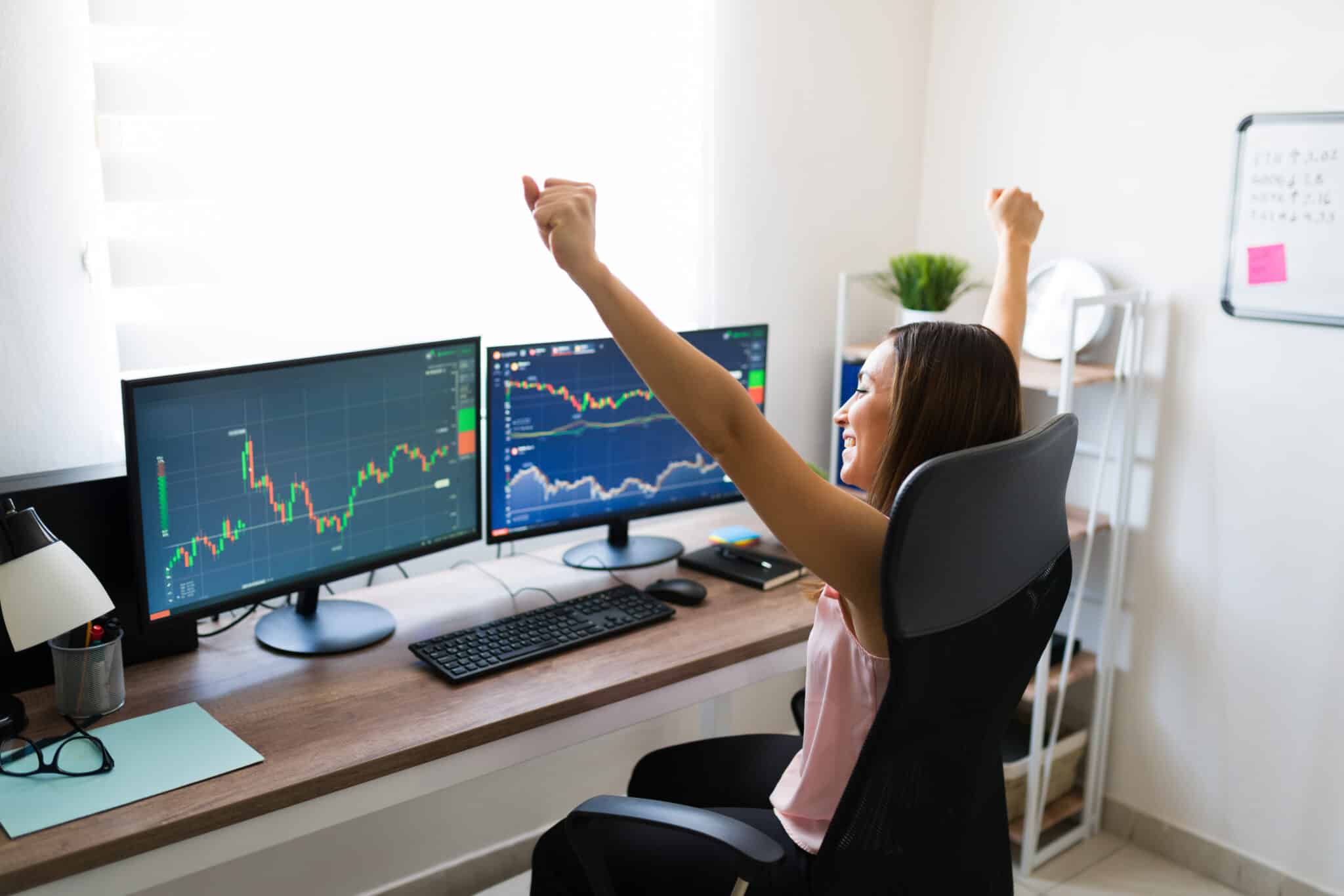 Yes, I did it! Successful stock broker made a good business deal online. Excited freelance woman buying stocks and celebrating a victory at work